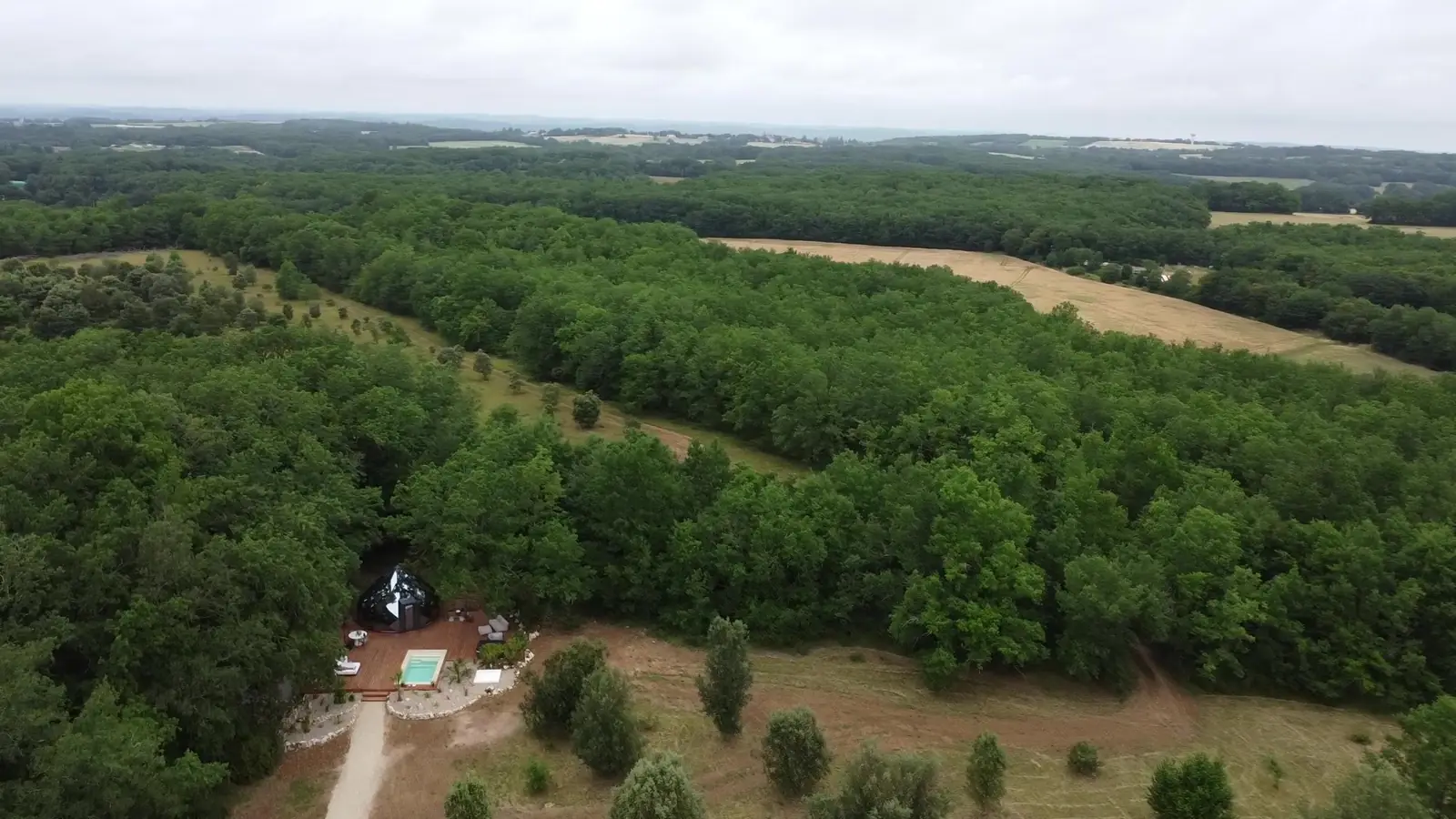 Le domaine vu du ciel : la forêt à perte de vue et le Zôme dans sa clairière