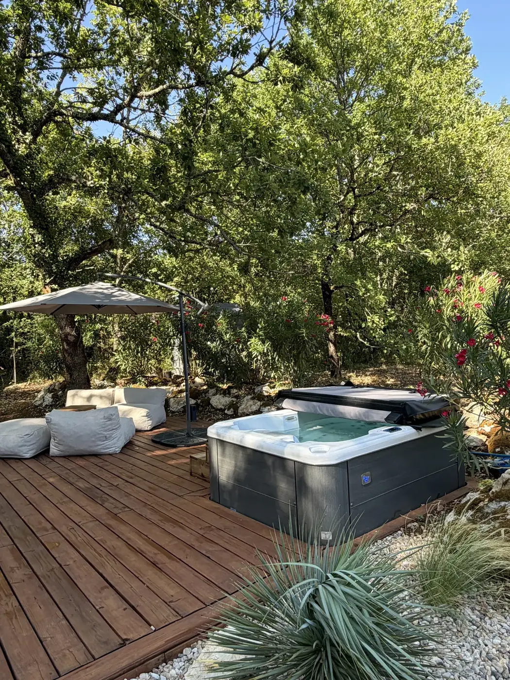 Le spa privatif sur la terrasse, sous les chênes
